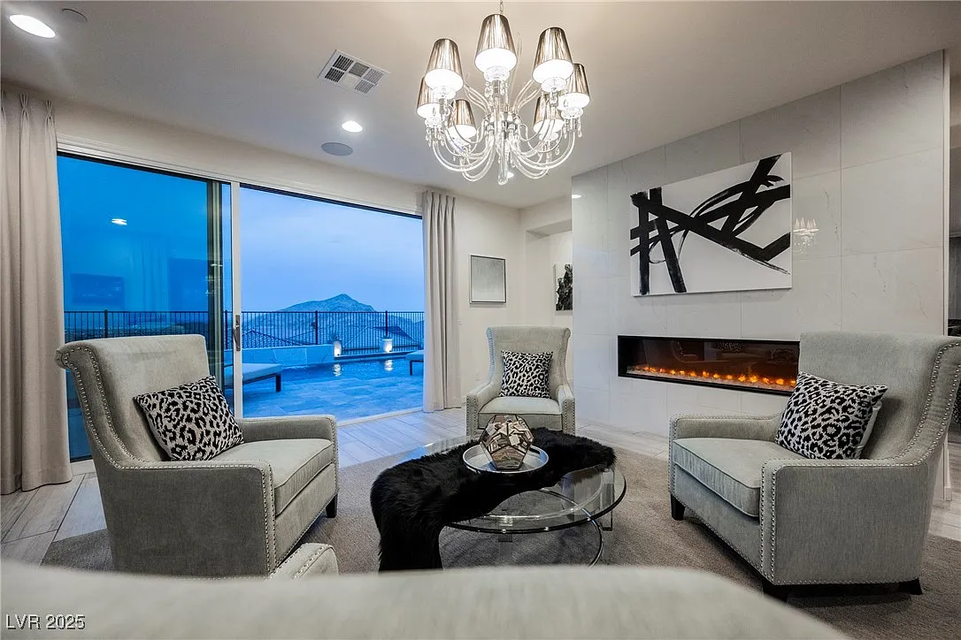 Sitting area with linear fireplace and pool view